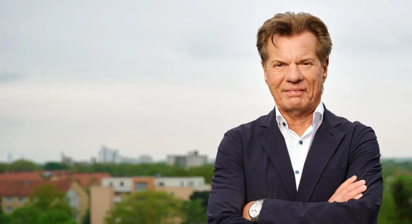 Alter Mann in Geschäftsanzug vor Stadt.