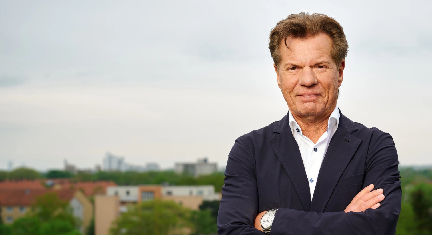 Alter Mann in Geschäftsanzug vor Stadt.