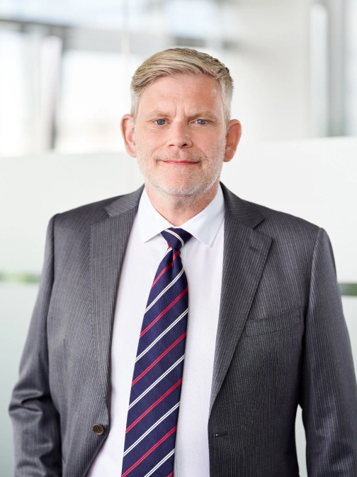 Hochwertiges Businessfoto eines Mannes im Anzug, professionell und vertrauenswürdig, geeignet für Karriere- und Unternehmenspräsentationen.