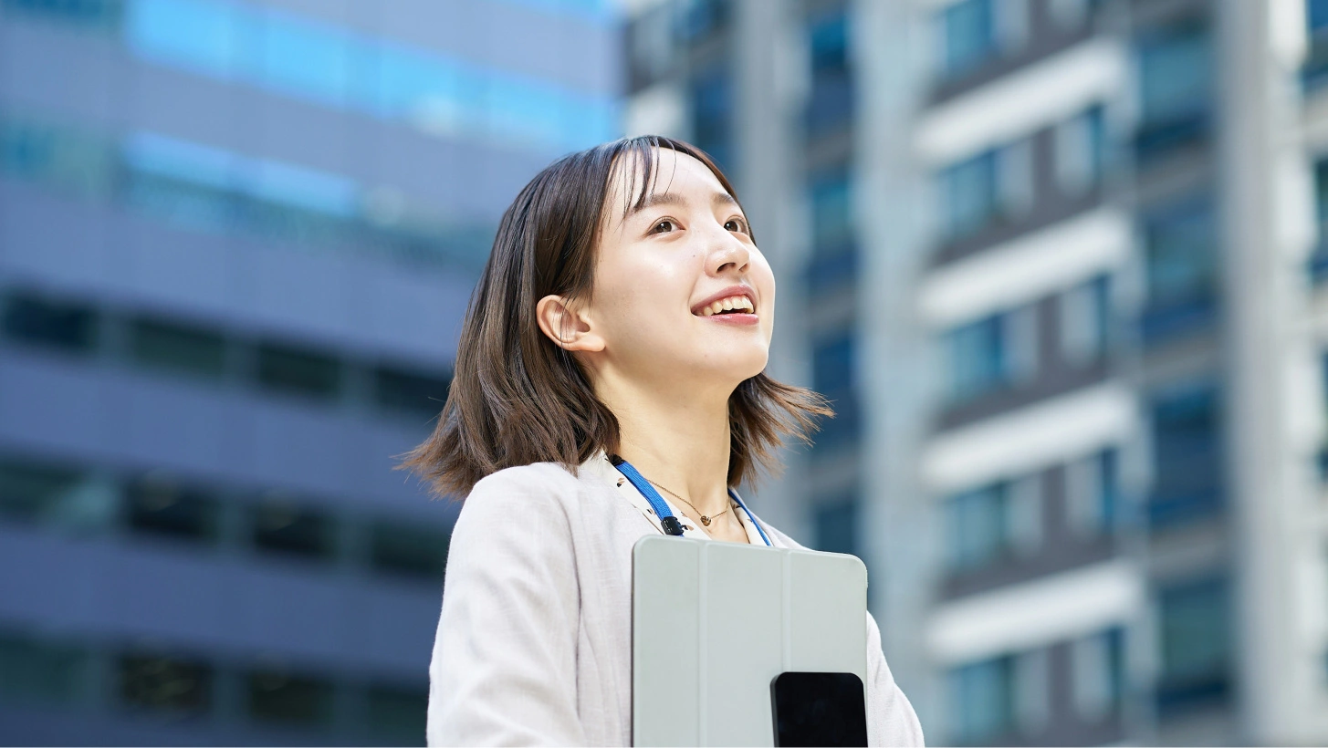 Alt Text: Junge Frau mit smartem Mobilitätsgerät vor modernen Gebäuden in der urbanen Umgebung, symbolisiert nachhaltige Mobilität und innovative Transportlösungen von ZAG.