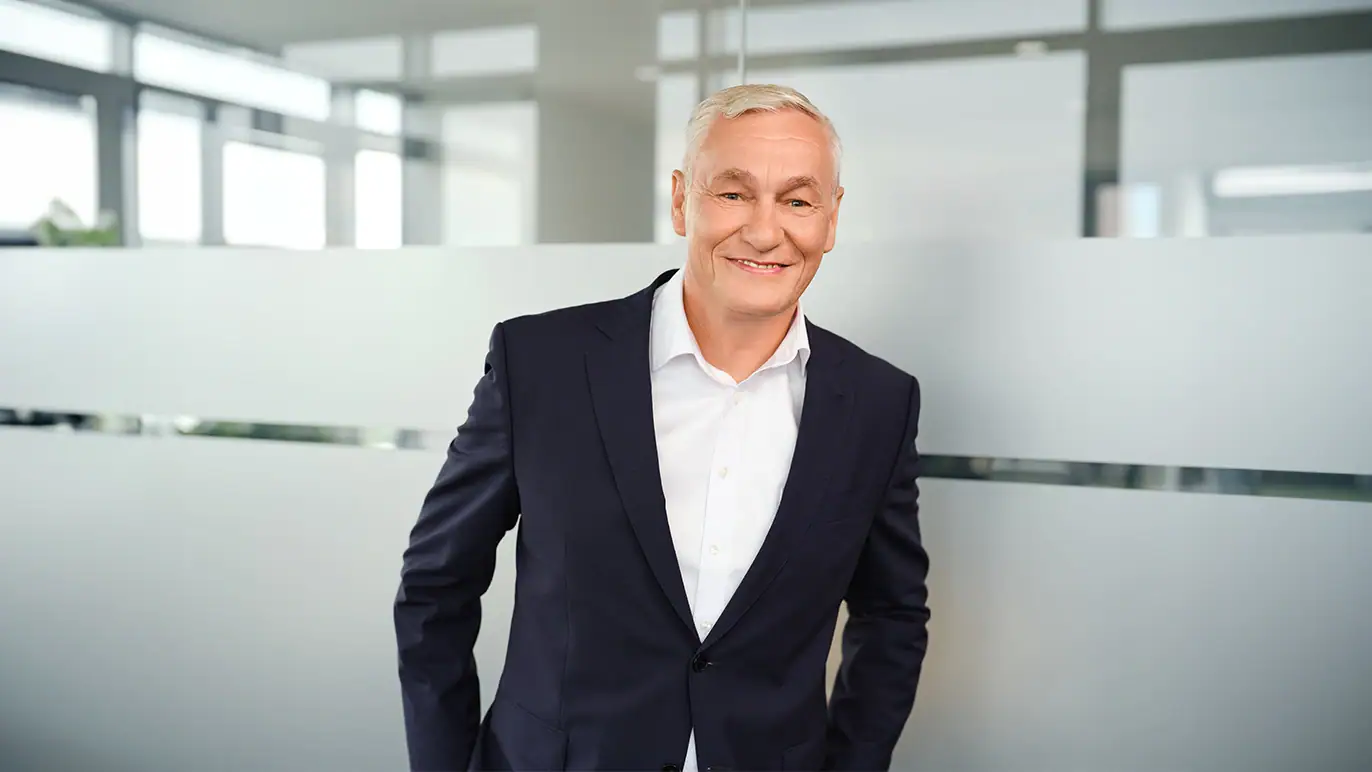 Senior Geschäftsführer in einem modernen Büro, trägt Anzug, wirkt professionell, Symbol für Leadership und Expertise bei ZAG, Personaldienstleistung und Arbeitsvermittlung.