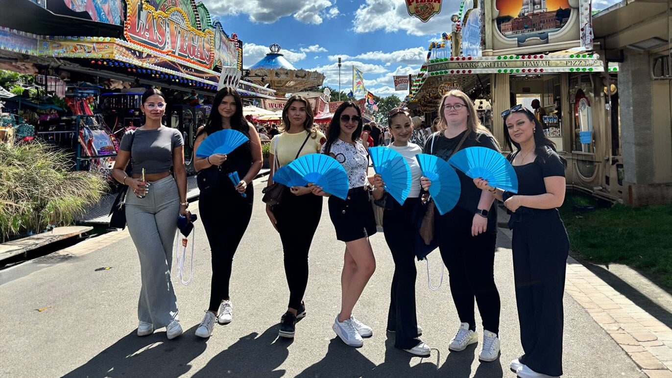 ZAG, Fröhliche Frauen mit blauen Fächern bei Oktoberfest-Besuch, festliche Stimmung, bayerisches Flair, Freizeit, Gemeinschaft, Tradition, Spaß auf dem Volksfest.